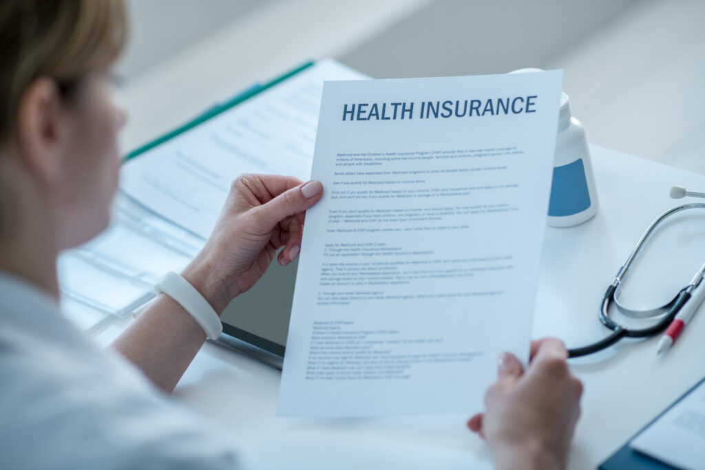 woman-lab-coat-reading-health-insurance-agreement